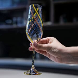 Handblown wine goblet with colorful twisted swirl stripes, handmade striped stemmed glass held in hand, decorative cocktail champagne glass