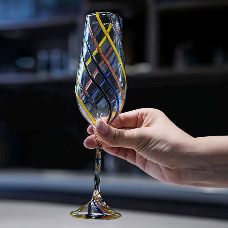 Handblown wine goblet with colorful twisted swirl stripes, handmade striped stemmed glass held in hand, decorative cocktail champagne glass